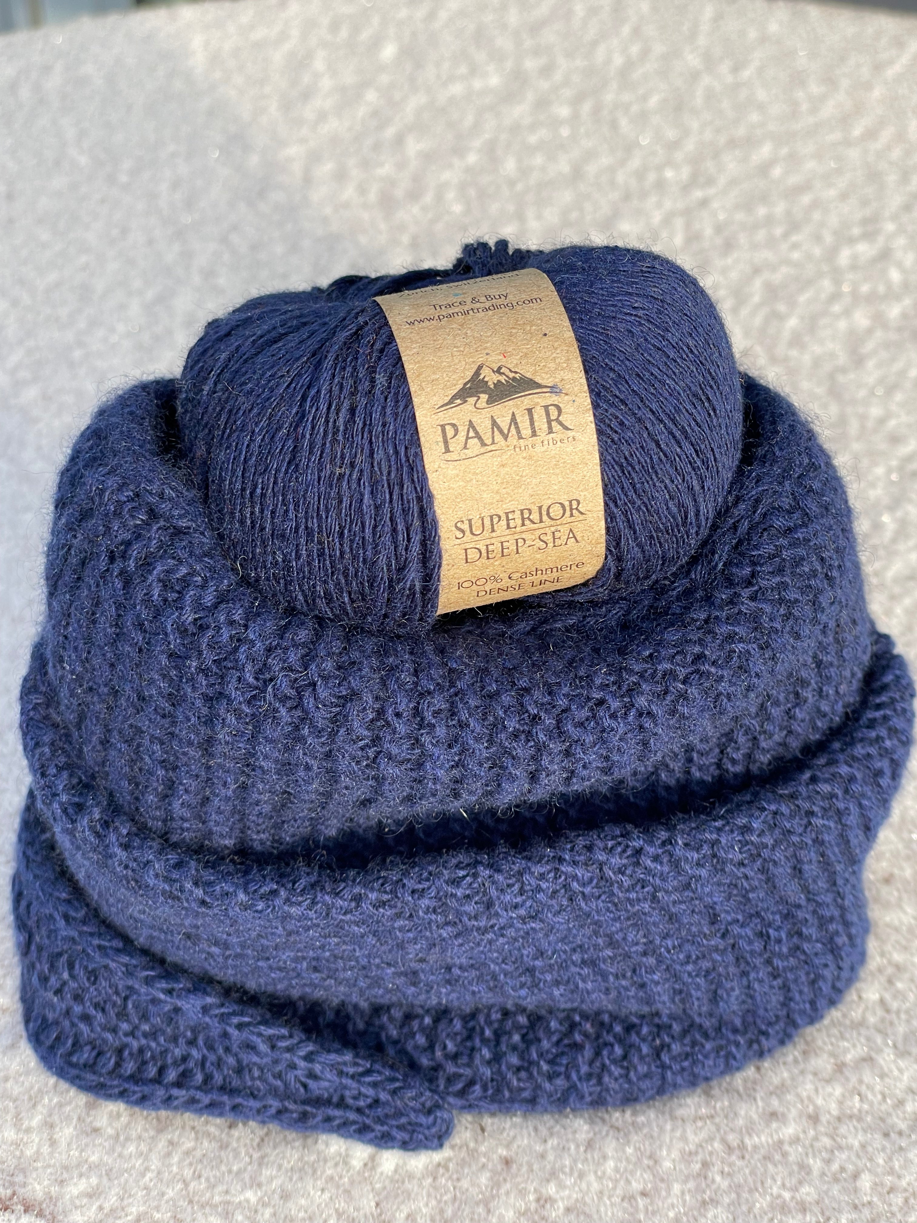 Sophie Scarf in Deep Sea aus Pamir Kaschmirgarn neben zwei Knäueln
