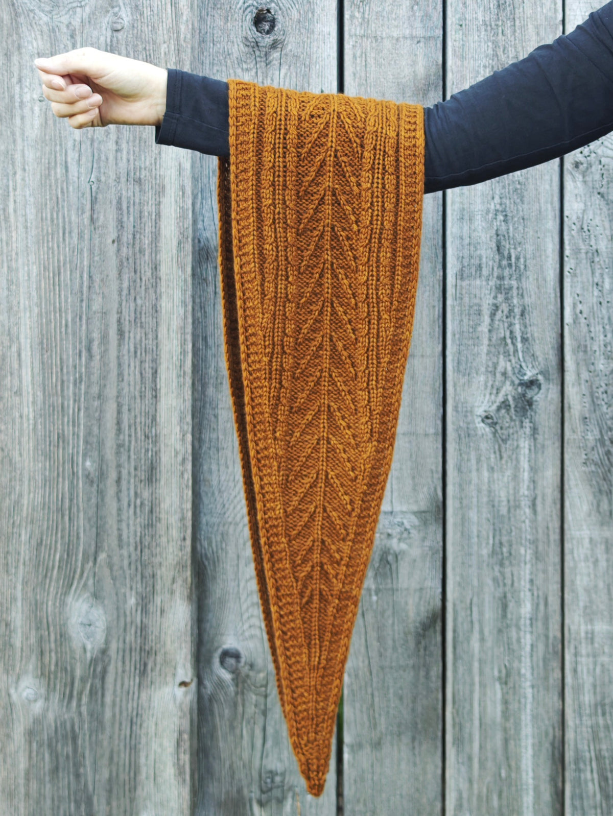 Sylva Shawlette von Sidispinnt aus CLASSIC Kaschmirgarn in Hazel vor einer Holzwand